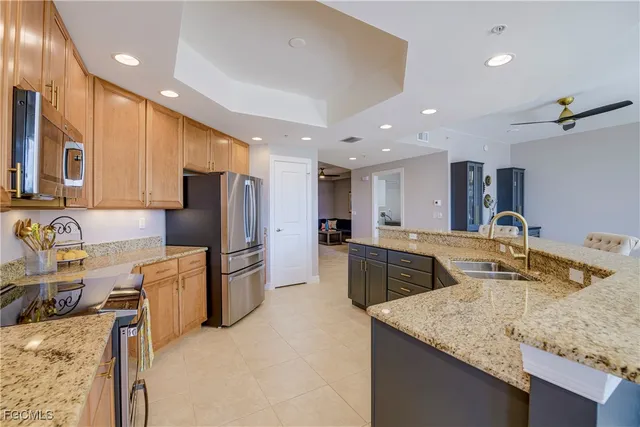 a kitchen with stainless steel appliances granite countertop sink stove refrigerator and cabinets