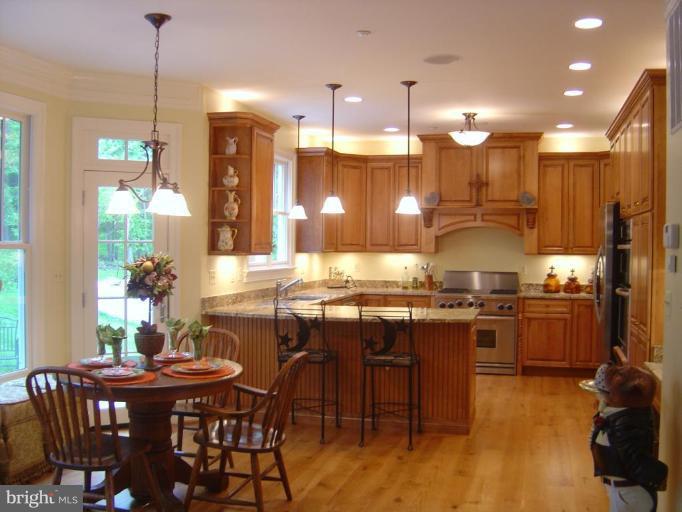 16820 Whites Store Road Boyds, MD 20841 - Photo 5 of 30 a kitchen with stainless steel appliances granite countertop a stove a refrigerator a kitchen island a dining table and chairs