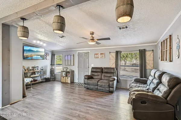 a kitchen with stainless steel appliances kitchen island granite countertop a refrigerator oven a sink dishwasher and white cabinets with wooden floor