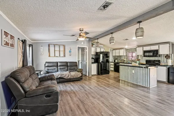 a kitchen with lots of counter top space a sink appliances and wooden floor