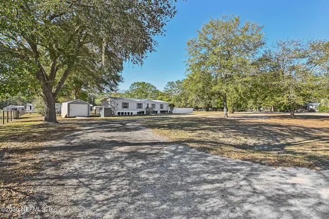a kitchen with stainless steel appliances kitchen island granite countertop a refrigerator oven a sink dishwasher and white cabinets with wooden floor