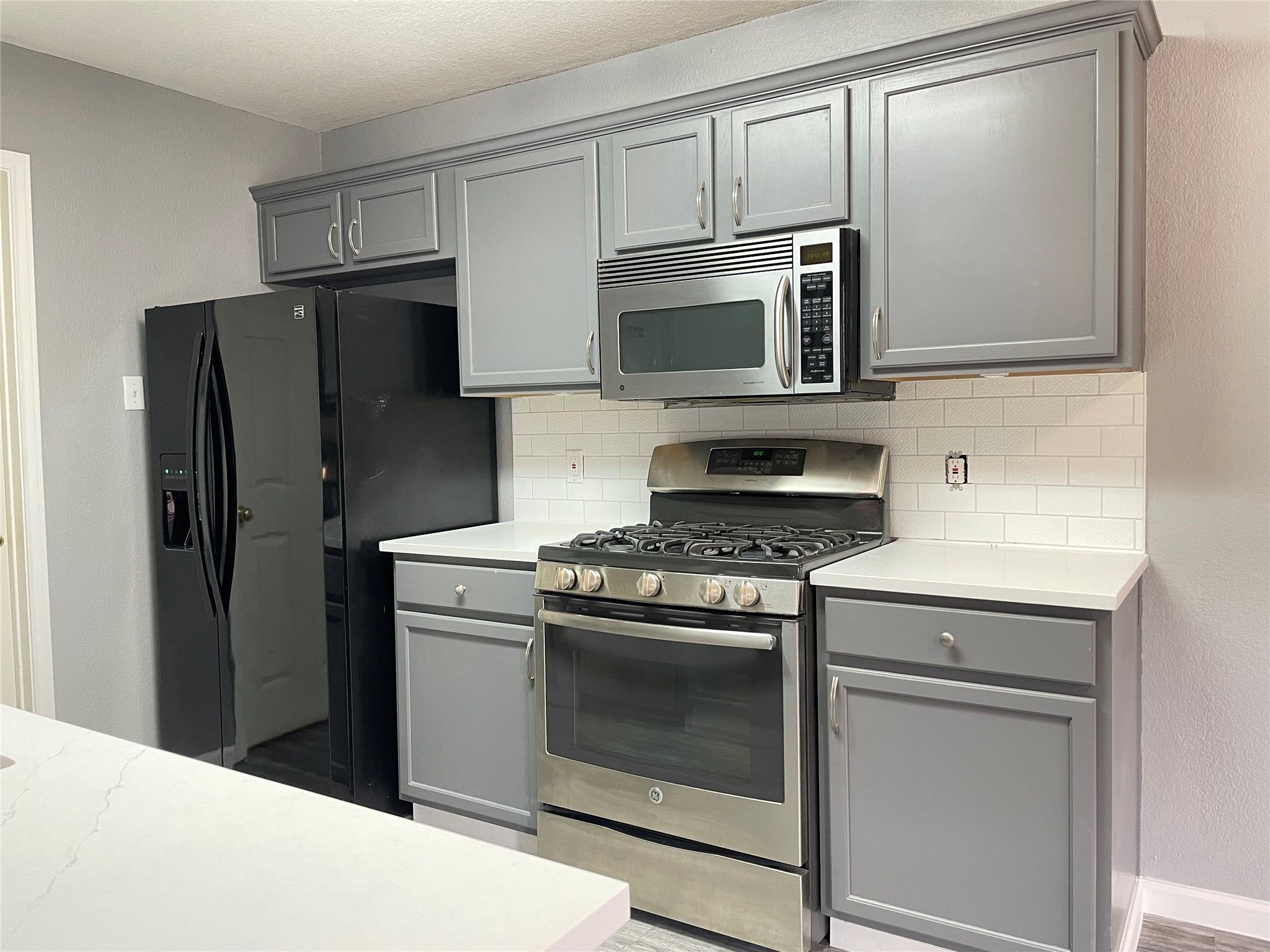 3638 Windhill Loop Round Rock, TX 78681 - Photo 12 of 32 Kitchen featuring grey cabinetry with crown molding, stainless steel appliances, subway tile backsplash, and light-toned countertops