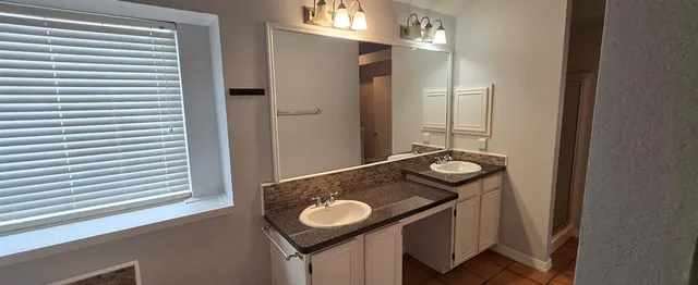 a bathroom with a granite countertop sink and a mirror