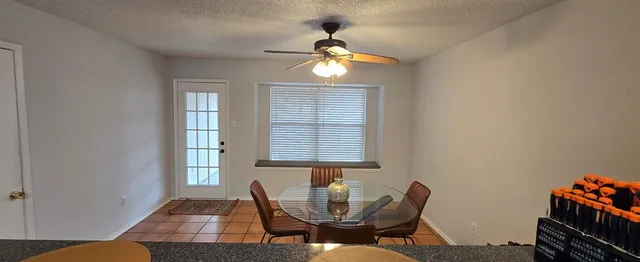 a dining room with chandelier fan and wooden floor
