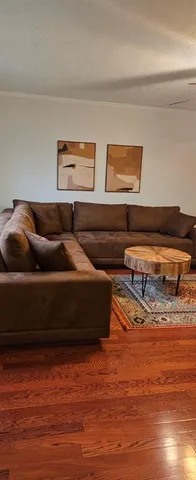 a living room with furniture and wooden floor