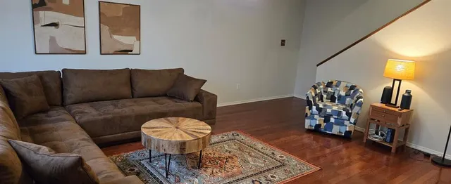 a living room with furniture and wooden floor