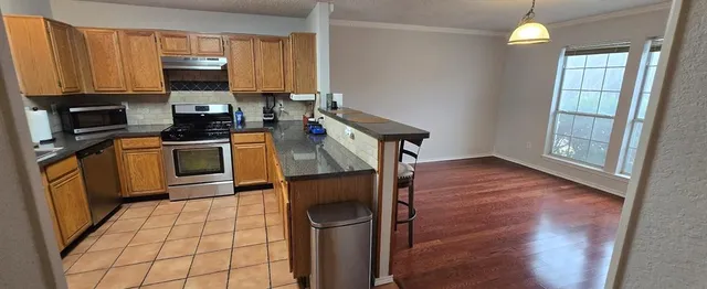 a kitchen with stainless steel appliances granite countertop a stove a sink and a refrigerator