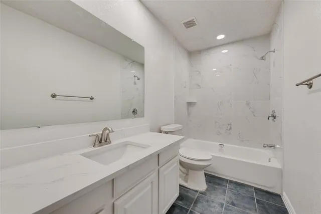 a front view of a house with a tree