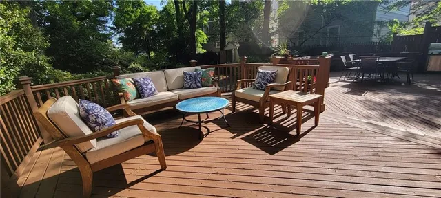 a roof deck with couches and wooden floor