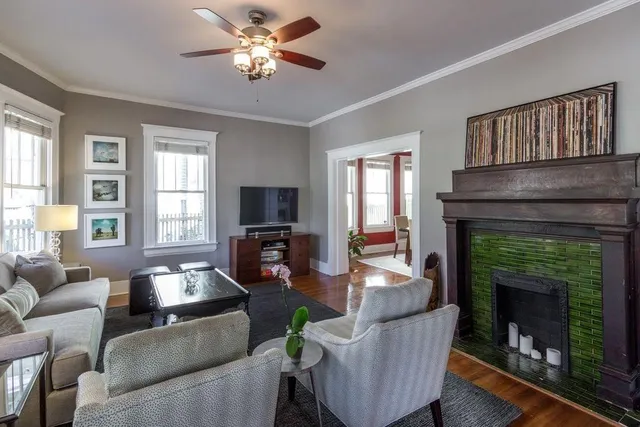 a living room with furniture a fireplace and a chandelier