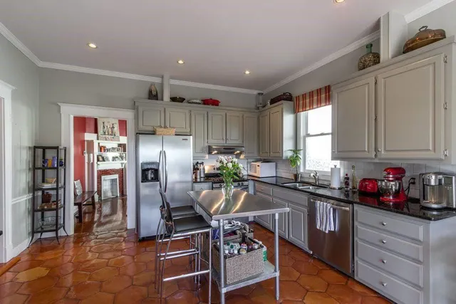 a kitchen with stainless steel appliances a sink a window and cabinets