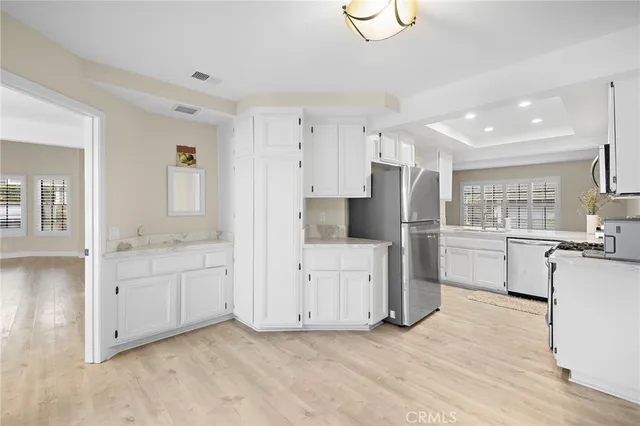 a kitchen with white cabinets and refrigerator