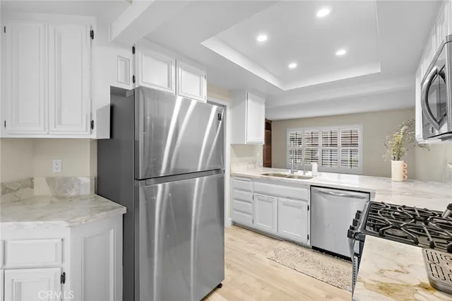 a kitchen with stainless steel appliances a refrigerator sink and cabinets
