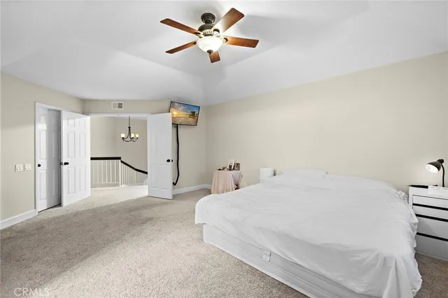 a spacious bedroom with a bed and a ceiling fan