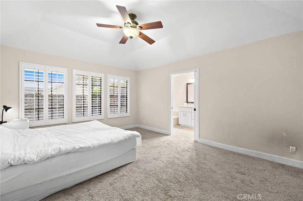 6 Fieldflower Irvine, CA 92614 - Photo 30 of 39 a spacious bedroom with a large bed and a chandelier fan