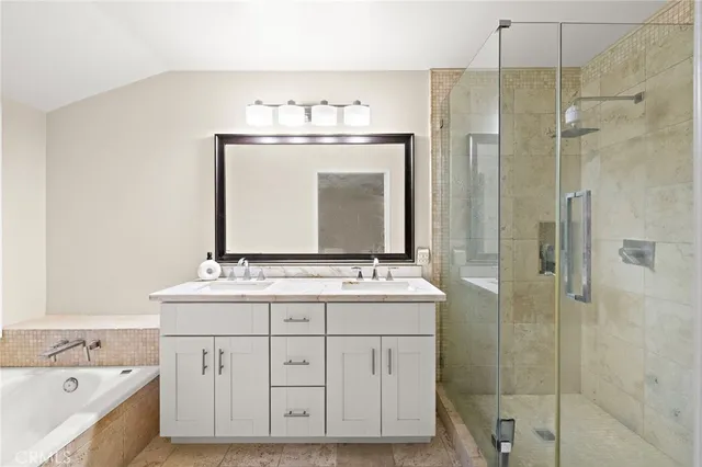 a bathroom with a double vanity sink mirror and bathtub
