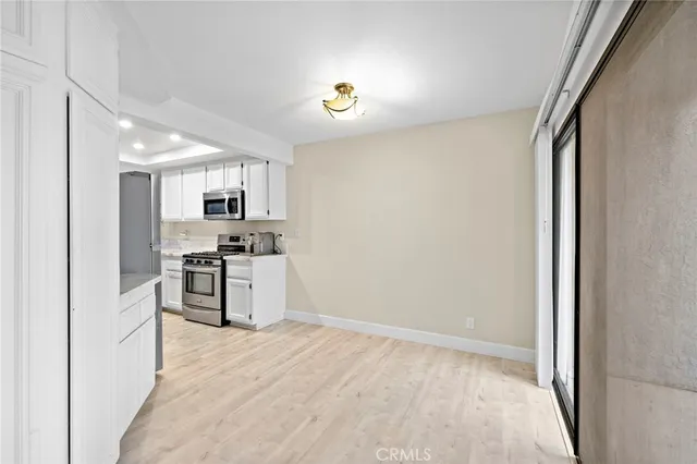 a kitchen with white cabinets and stainless steel appliances