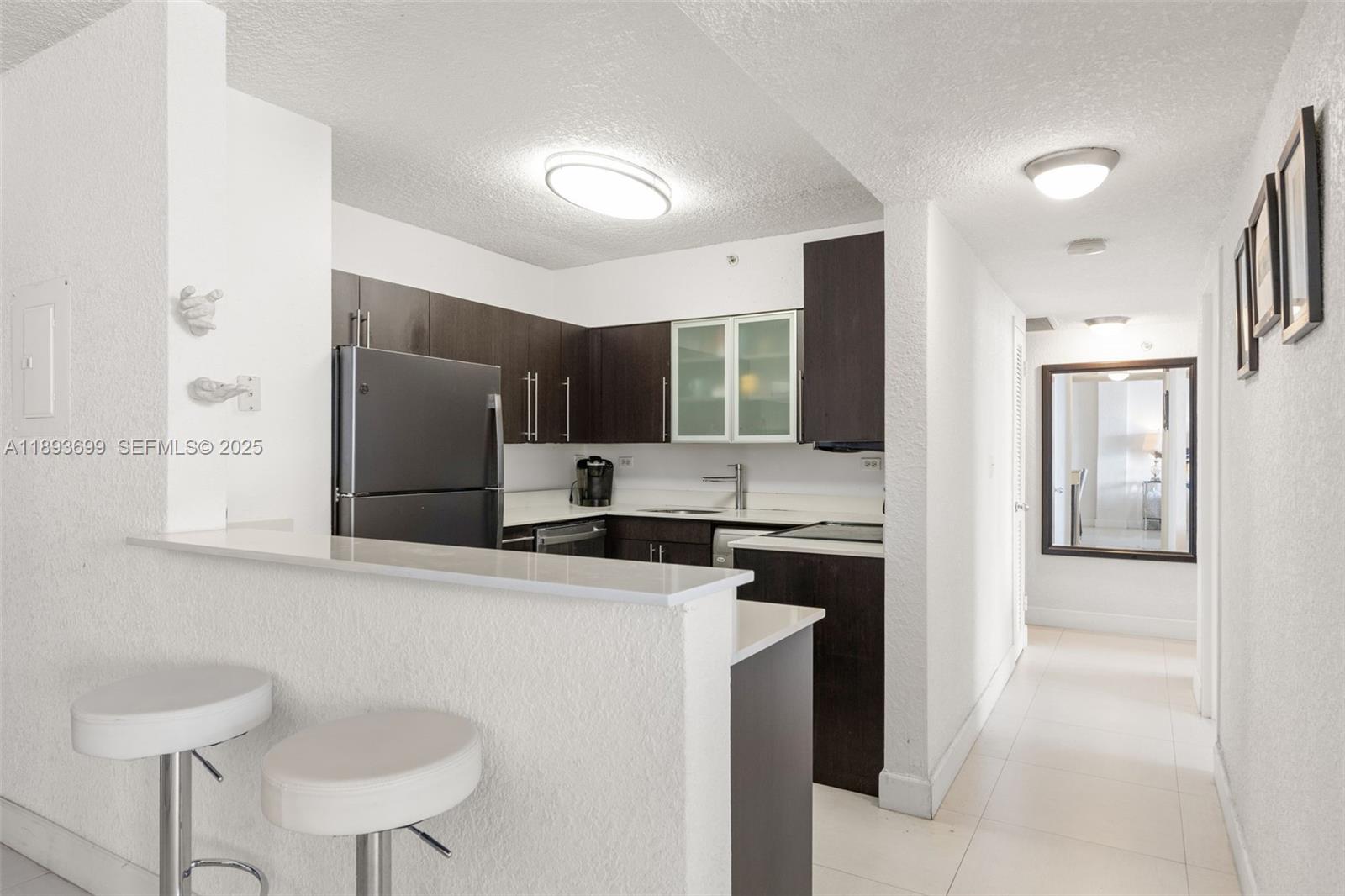 1500 Bay Road, Unit 1122S Miami Beach, FL 33139 - Photo 5 of 32 a kitchen with stainless steel appliances granite countertop a refrigerator and a stove top oven