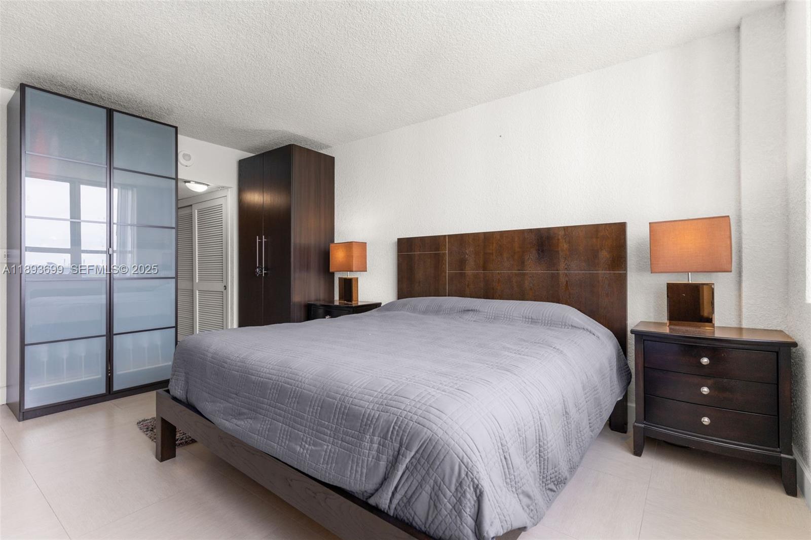 1500 Bay Road, Unit 1122S Miami Beach, FL 33139 - Photo 8 of 32 a bedroom with a bed and a dresser