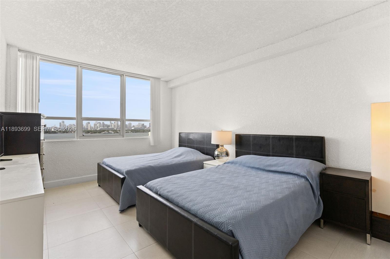 1500 Bay Road, Unit 1122S Miami Beach, FL 33139 - Photo 9 of 32 a bedroom with a bed and large window