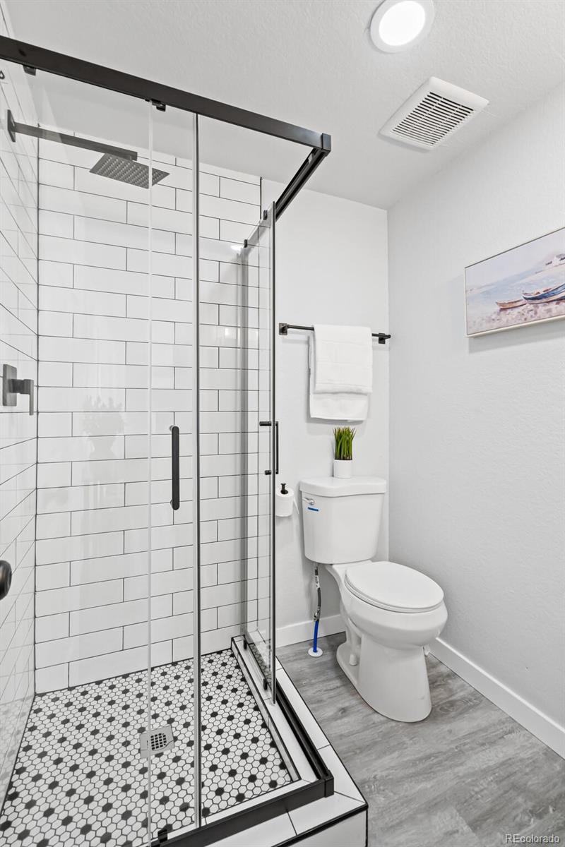 4831 Depew Street Denver, CO 80212 - Photo 13 of 35 a bathroom with a toilet a window and shower