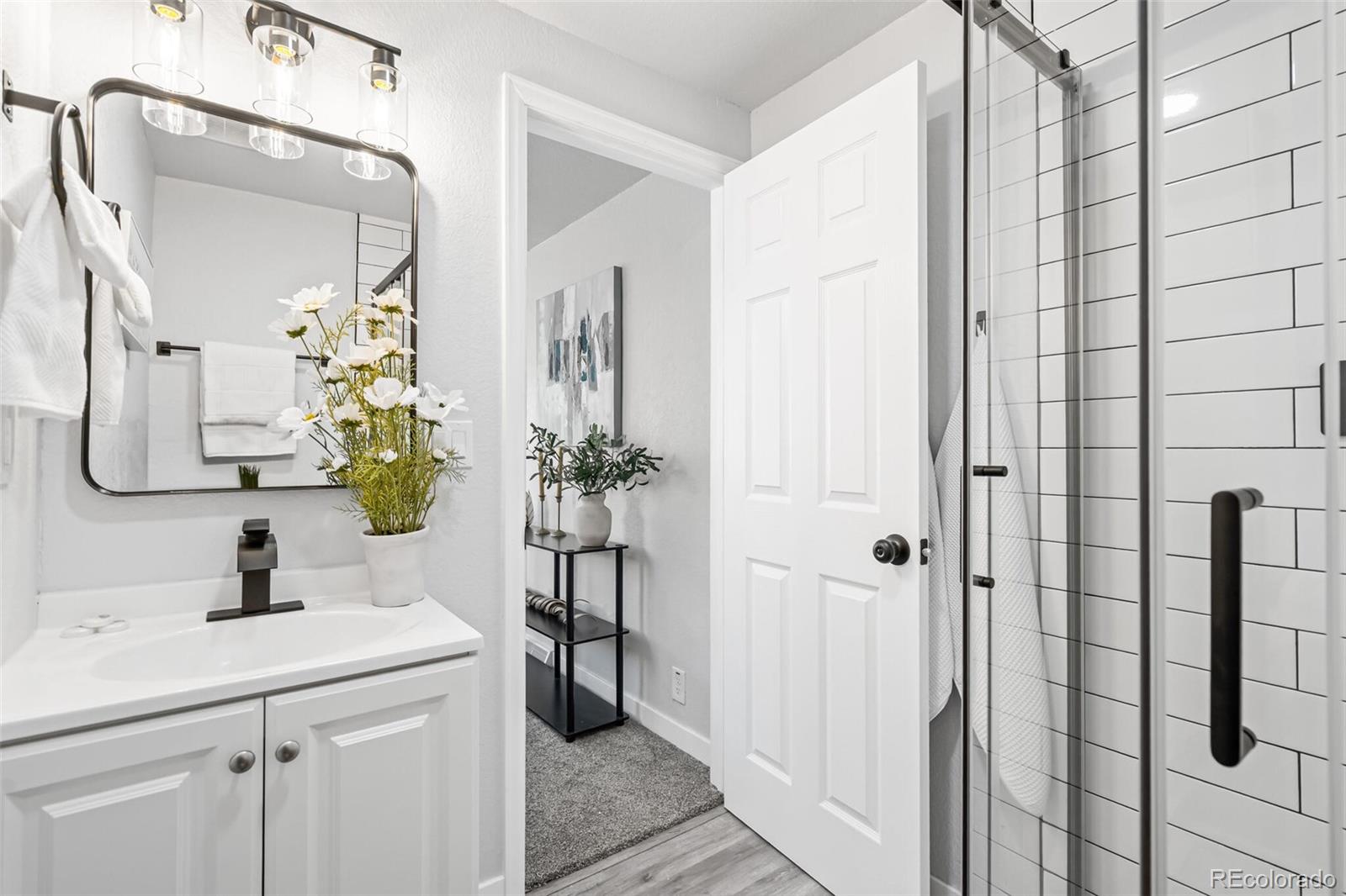 4831 Depew Street Denver, CO 80212 - Photo 14 of 35 a bathroom with a sink a mirror and a shower