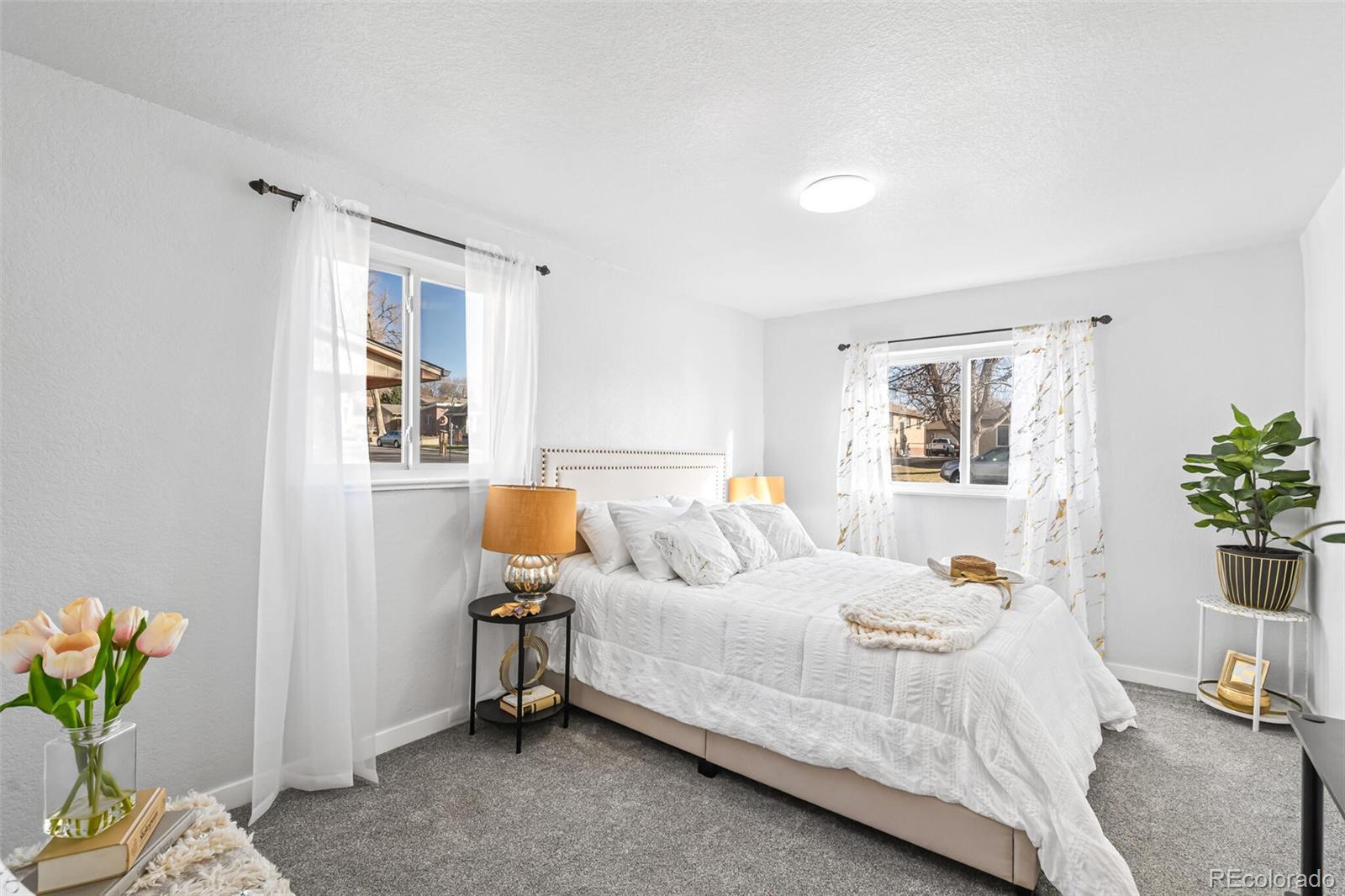 4831 Depew Street Denver, CO 80212 - Photo 16 of 35 a bedroom with a bed a potted plant on dresser and a window