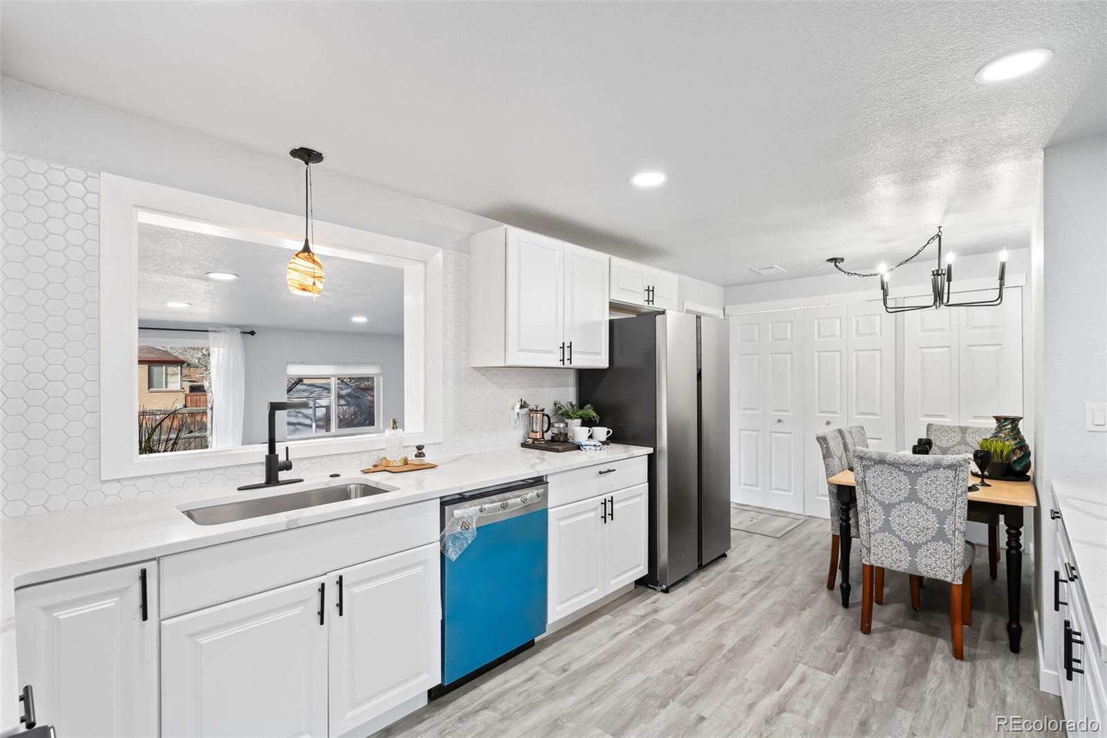 4831 Depew Street Denver, CO 80212 - Photo 22 of 35 a kitchen with a sink a refrigerator and chairs