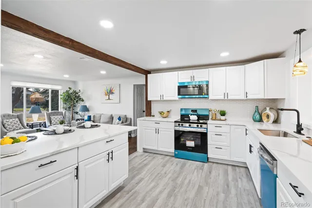 a kitchen with a sink a stove refrigerator and cabinets