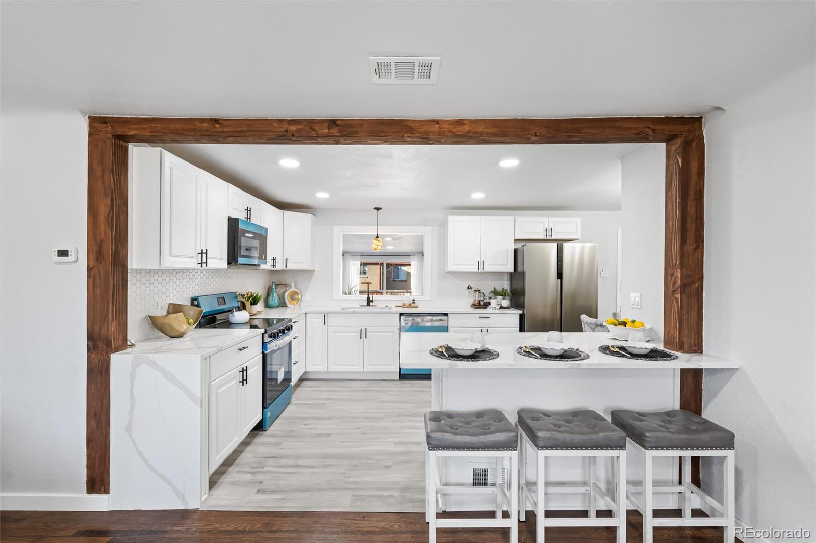 4831 Depew Street Denver, CO 80212 - Photo 26 of 35 a kitchen with stainless steel appliances kitchen island granite countertop a sink and cabinets