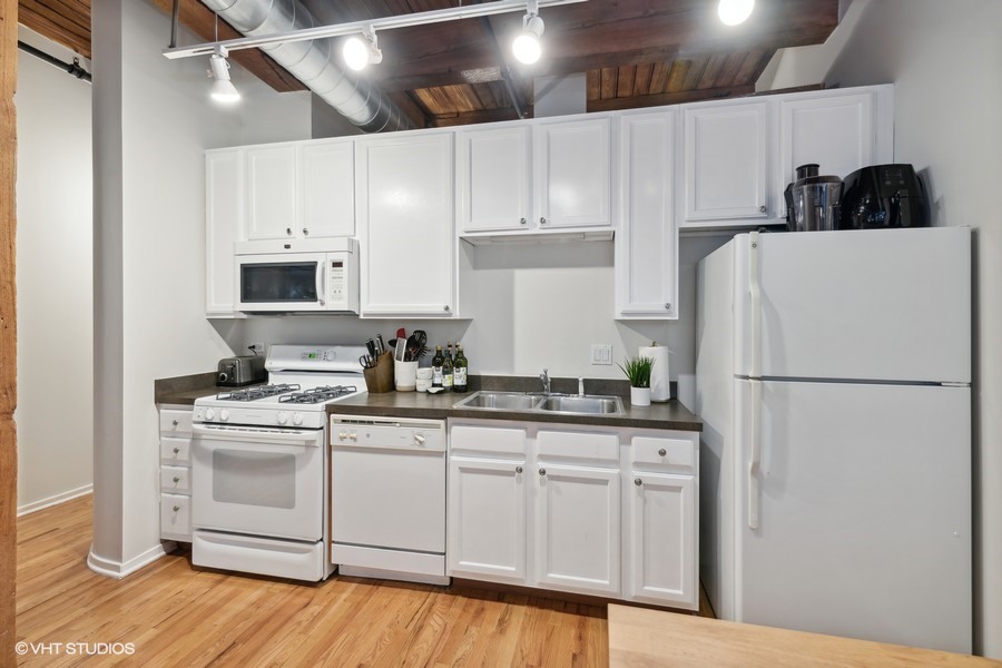 1500 West Monroe Street, Unit 518 Chicago, IL 60607 - Photo 6 of 14 a kitchen with white cabinets and white appliances