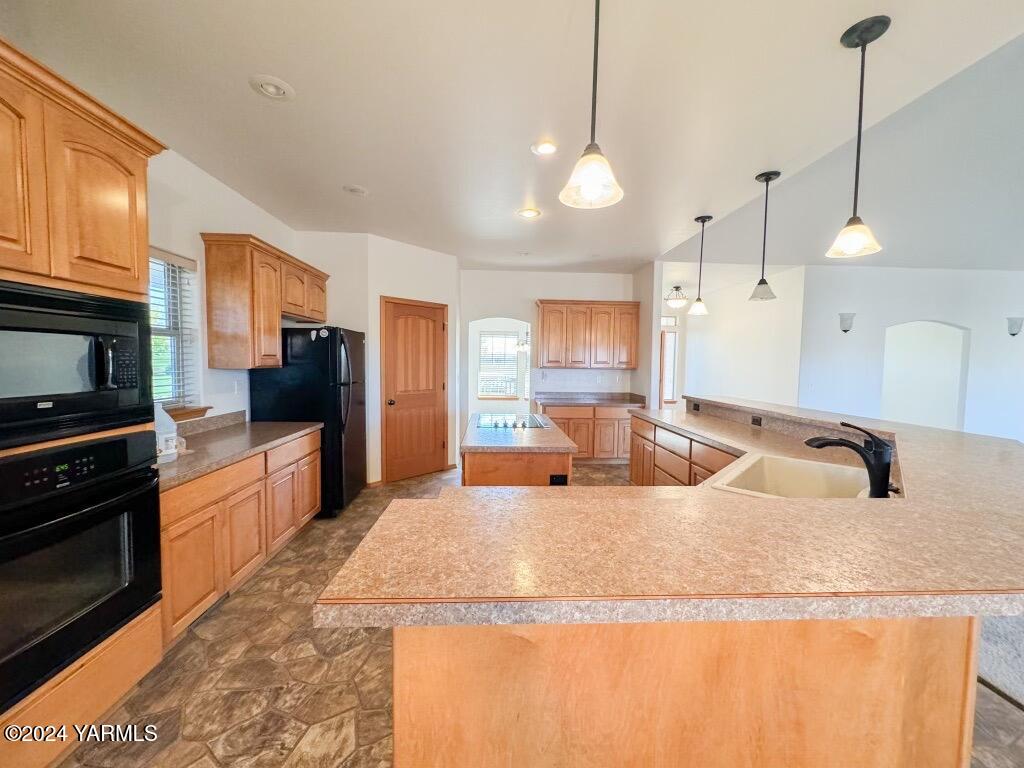 699 Alexander Road Sunnyside, WA 98944 - Photo 14 of 27 a large kitchen with granite countertop a sink a counter top space appliances and cabinets