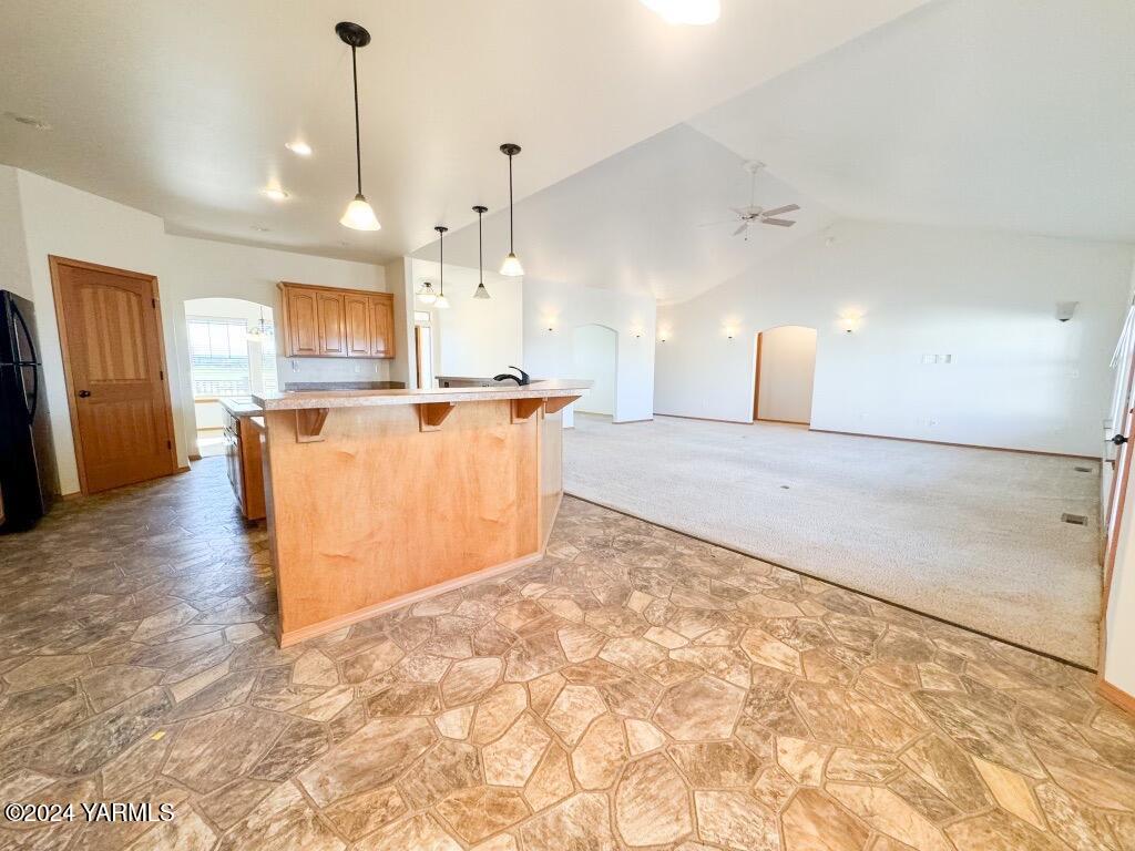699 Alexander Road Sunnyside, WA 98944 - Photo 16 of 27 a view of a kitchen with kitchen island a sink wooden floor and a counter top space