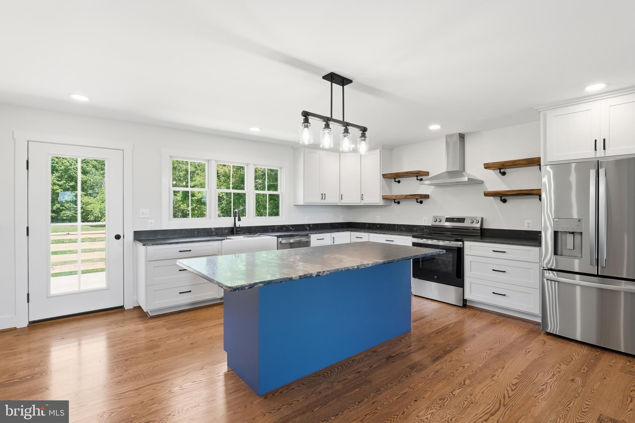 1548 James City Road Reva, VA 22735 - Photo 12 of 48 a kitchen with stainless steel appliances granite countertop a sink a stove a refrigerator and island with wooden floor