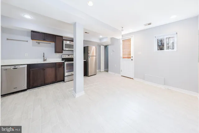 a large white kitchen with kitchen island a sink stainless steel appliances and cabinets
