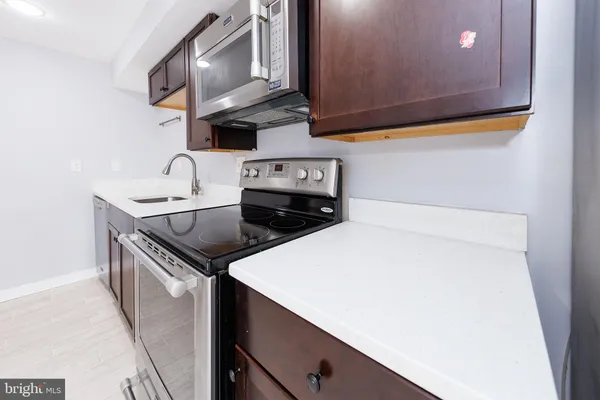 a kitchen with stainless steel appliances a sink a stove and cabinets
