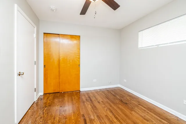 an empty room with wooden floor and closet