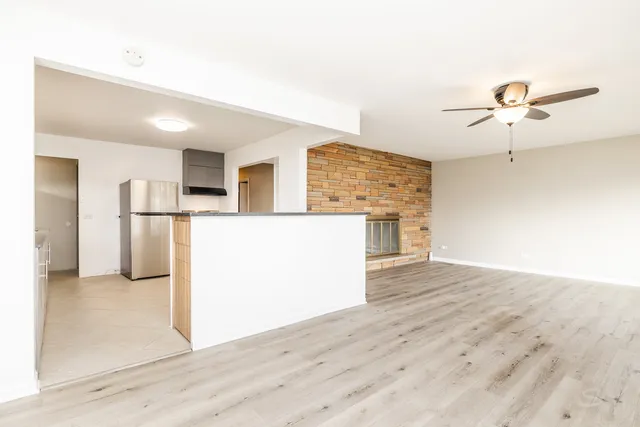 a view of a kitchen with wooden floor and a refrigerator