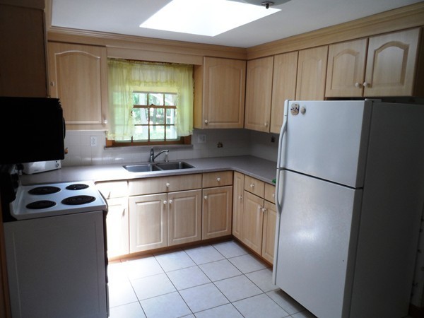 25 Eaton Road Framingham, MA 01701 - Photo 4 of 11 a kitchen with a refrigerator sink and cabinets