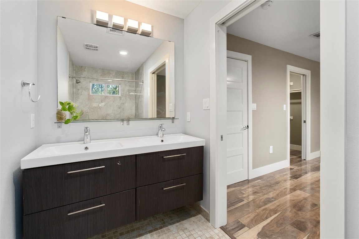 1204 Eleanor Street Austin, TX 78721 - Photo 18 of 26 a bathroom with a double vanity sink and a mirror