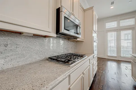 a kitchen with stainless steel appliances granite countertop a stove and a microwave