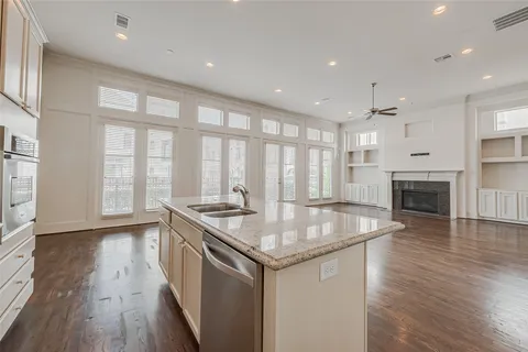 a kitchen with stainless steel appliances granite countertop a stove and a wooden floors