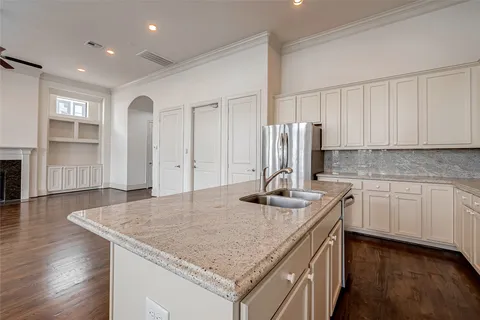 a kitchen with stainless steel appliances granite countertop a sink refrigerator and cabinets