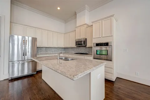 a kitchen with stainless steel appliances granite countertop a refrigerator a sink and a stove