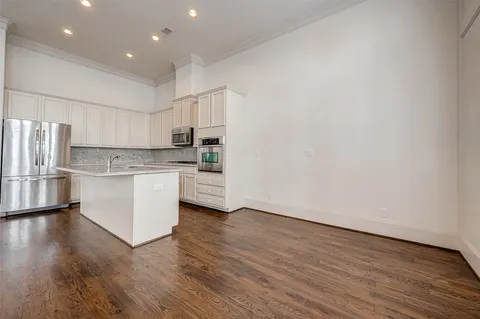 a view of kitchen with granite countertop cabinets and refrigerator