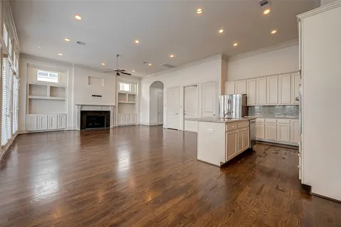 a kitchen with stainless steel appliances a refrigerator and wooden floor