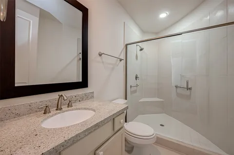 a bathroom with a granite countertop sink toilet and shower
