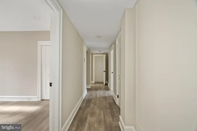 a view of a hallway with wooden floor and entryway