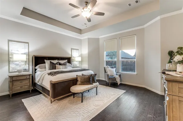 a bedroom with a bed wooden floor and window