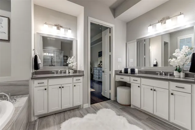 a spacious bathroom with a granite countertop sink double and mirror